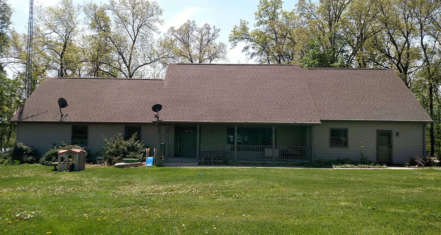 Ranch house with a shingle roof and vinyl siding