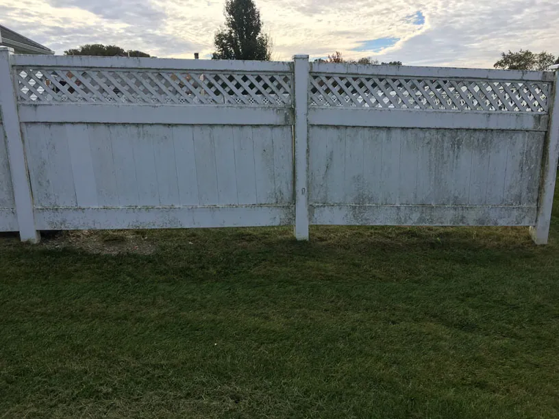 Vinyl fence streaked with mildew before washing